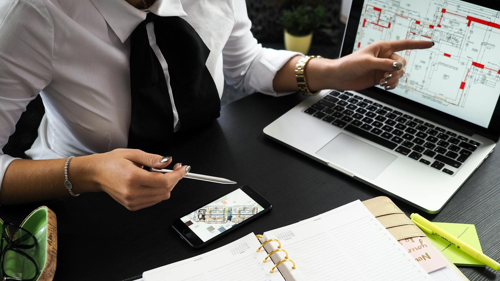 person pointing on the screen of a laptop